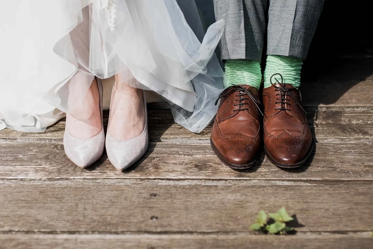Wedding celebration - bride and groom's feet on wooden deck with green socks