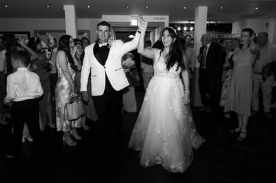 Joyous wedding scene at Clarence Hall, with a bride and groom dancing amid celebrating guests, capturing the joyous atmosphere.