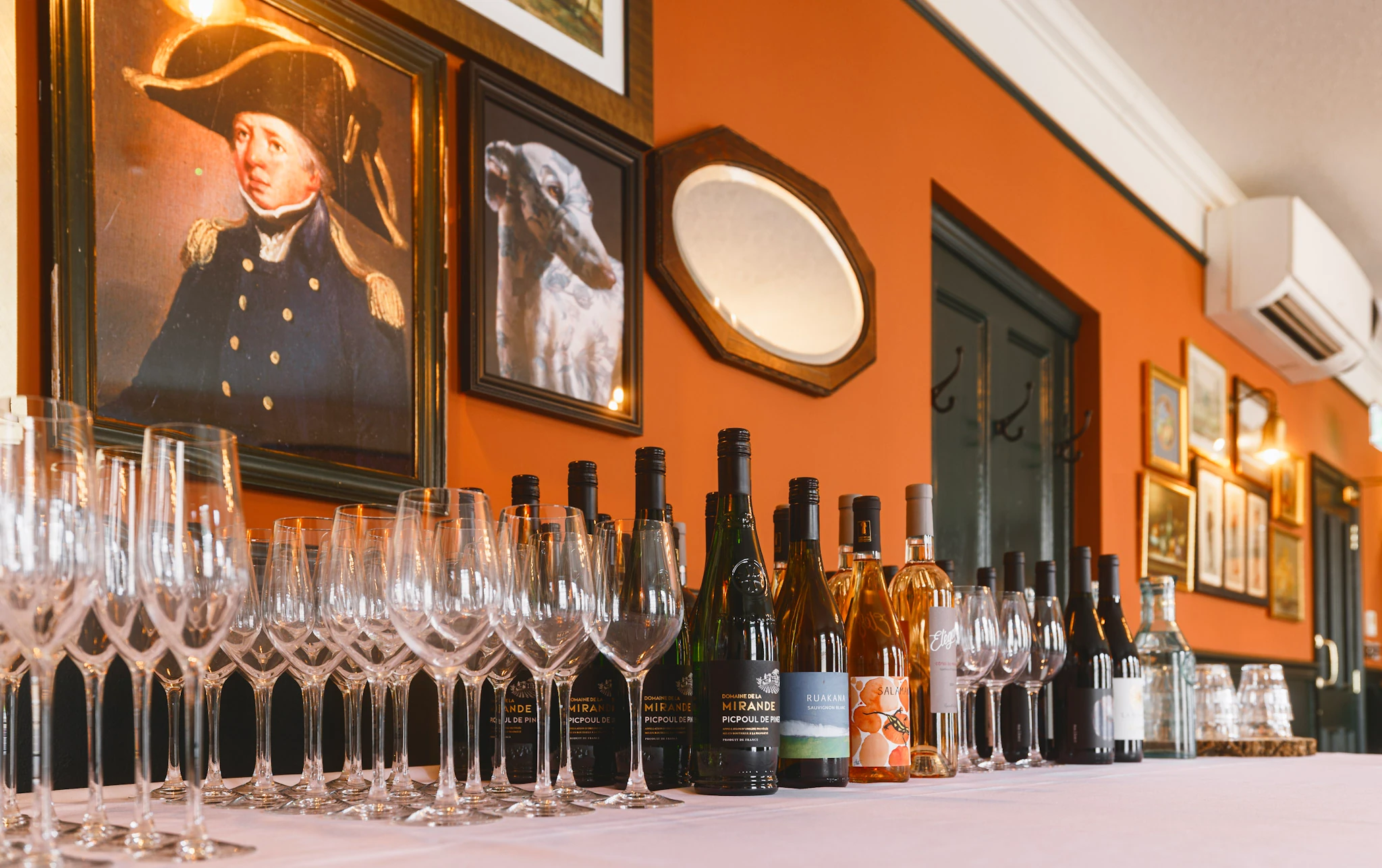 Wine glasses and bottles lined up on the bar at The Admiral Hardy