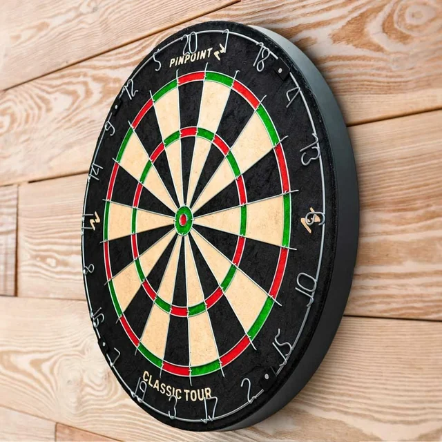 A black dartboard with a green center and red outer rings is mounted on a wooden wall, with the word "Dart" in gold letters above the center. The dartboard has a "10" in the center, indicating a target of 10. The image is taken from a slightly above and to the side perspective, emphasizing the dartboard's size and the wall's texture.